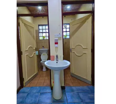 a bathroom with a toilet and a sink at A private bedroom in a shared home in Arusha in Arusha