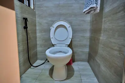 a bathroom with a white toilet in a stall at Favourites home-English breakfast in Arusha