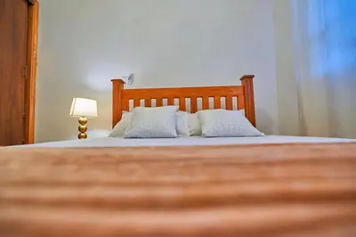 a bedroom with a bed with two white pillows at Favourites home-English breakfast in Arusha