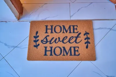 a home sweet home sign on a tile floor at Favourites home-English breakfast in Arusha