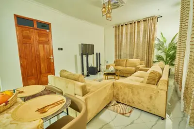 a living room with a couch and a table at Favourites home-English breakfast in Arusha