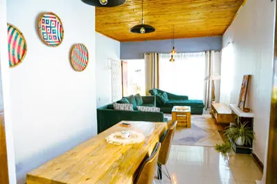 a living room with a wooden table and a couch at Garden Villa Homestay in Arusha