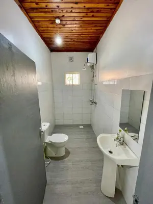 a bathroom with a toilet and a sink at Garden Villa Homestay in Arusha