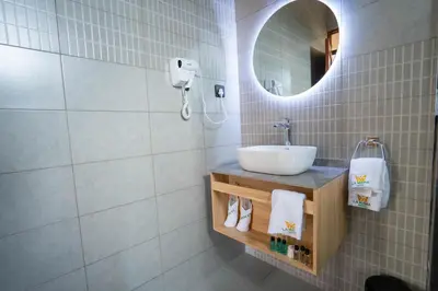 a bathroom with a sink and a mirror at La Mama Hotel in Uru