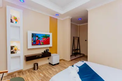 a bedroom with a bed and a tv on the wall at La Mama Hotel in Uru