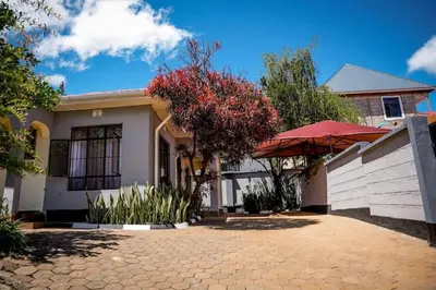 a house with a brick driveway in front of it at Kwetu Arusha Villa in Arusha
