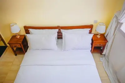 a bedroom with a bed with pillows and two lamps at Kwetu Arusha Villa in Arusha