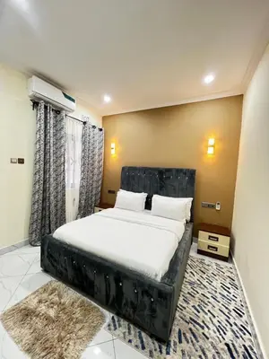 a bedroom with a large bed with a black headboard at Hadraj Sokoine Apartment1 in Arusha
