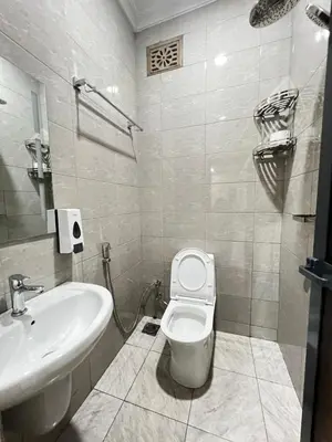 a bathroom with a white toilet and a sink at Hadraj Sokoine Apartment1 in Arusha