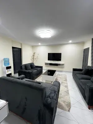 a living room with couches and a flat screen tv at Hadraj Sokoine Apartment1 in Arusha