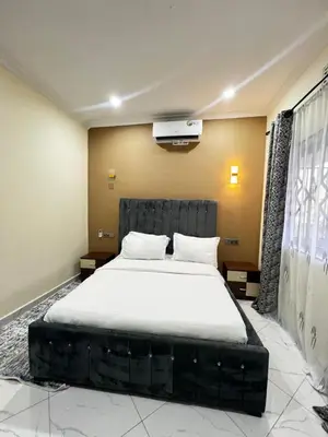a bedroom with a large bed with white sheets at Hadraj Sokoine Apartment1 in Arusha