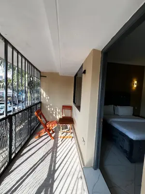 a room with a balcony with a bed and a window at Hadraj Sokoine Apartment1 in Arusha
