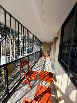 a balcony with orange chairs on a building at Hadraj Sokoine Apartment1 in Arusha