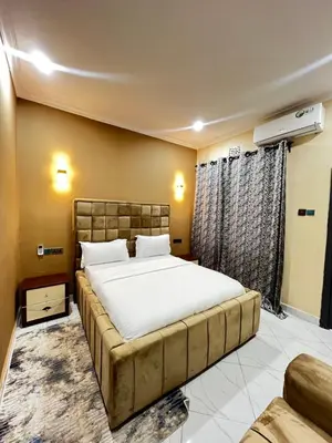 a bedroom with a large bed and a couch at Hadraj Sokoine Apartment2 in Arusha