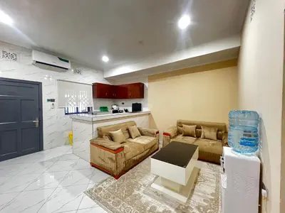 a living room with two couches and a kitchen at Hadraj Sokoine Apartment2 in Arusha