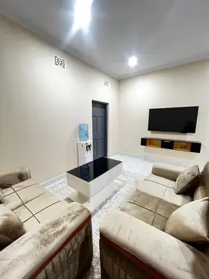 a living room with two couches and a flat screen tv at Hadraj Sokoine Apartment2 in Arusha