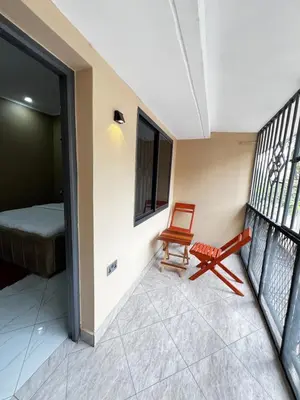 a room with a balcony with a chair and a bed at Hadraj Sokoine Apartment2 in Arusha