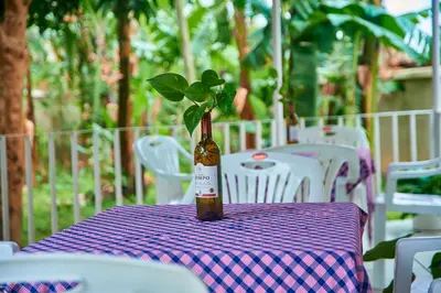 a bottle with a plant in it sitting on a table at Villa Malkia's in Enaboishu
