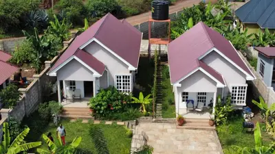 a small white house with a purple roof at Rejoice Evermore Homes in Arusha