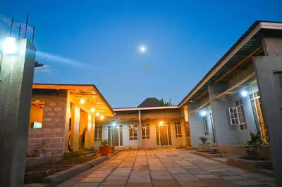 a house with a courtyard at night with lights at Rejoice Evermore Homes in Arusha