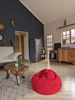 a living room with a red ottoman in the middle of a room at Rejoice Evermore Homes in Arusha