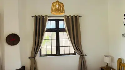 a window with brown curtains in a room at Tulusia Lake View in Arusha