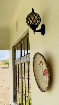 a lamp and a plate on a wall next to a window at Tulusia Lake View in Arusha