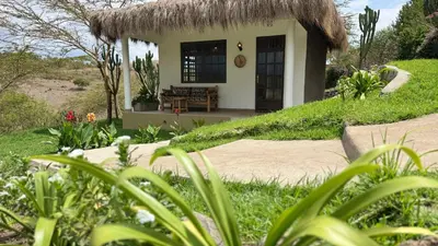 a small house with a grass roof at Tulusia Lake View in Arusha