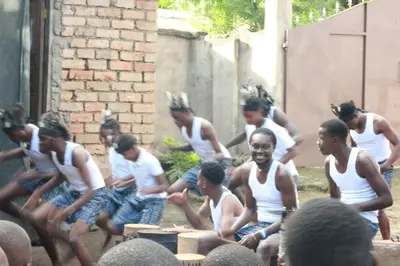 a group of men in white tank tops sitting at WauTaMaDuNi Homestay in Usa River
