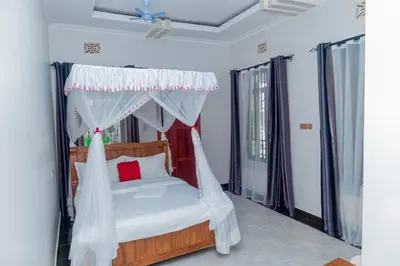 a bedroom with a bed with a canopy at African Jacana Inn and Camps in Mto wa Mbu