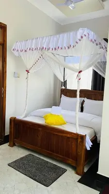 a bedroom with a bed with a canopy at African Jacana Inn and Camps in Mto wa Mbu