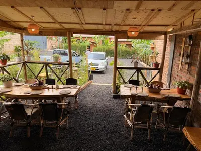 a patio with wooden tables and chairs in a building at Baraka Home in Arusha