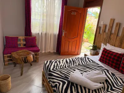 a bedroom with a zebra print bed and a door at Baraka Home in Arusha