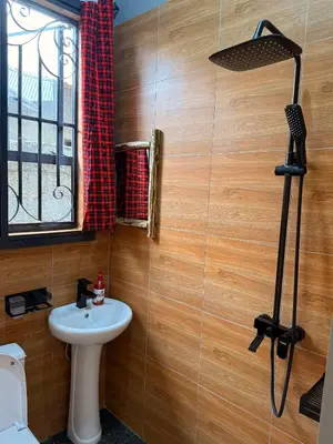 a bathroom with a white sink and a window at Baraka Home in Arusha
