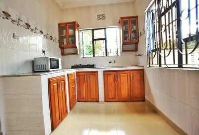 a kitchen with wooden cabinets and a microwave at Havijo Residence