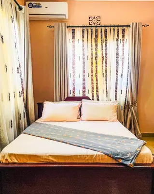 a bed in a room with a window with curtains at Havijo Residence