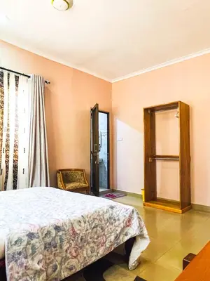 a bedroom with a bed and a chair and a window at Havijo Residence