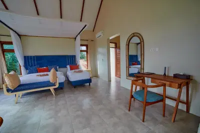 a bedroom with a bed and a desk and a table at Tarangire Luxury Hideaway in Mbesi