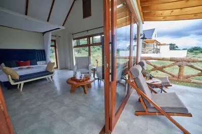 a living room with a bed and a table and chairs at Tarangire Luxury Hideaway in Mbesi