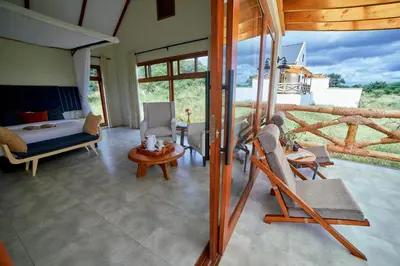 a room with a bed and a table and chairs at Tarangire Luxury Hideaway in Mbesi