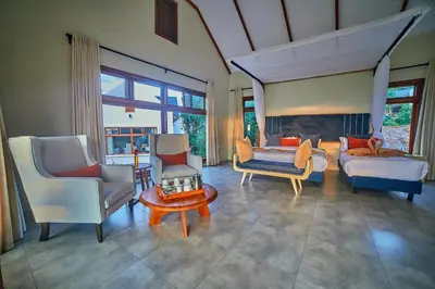 a living room with a couch and chairs and a fireplace at Tarangire Luxury Hideaway in Mbesi