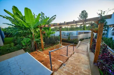 a patio with a wooden pergola and a ramp at Pamoja Farm Villas in Karatu