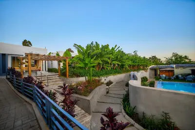 a house with a swimming pool next to a fence at Pamoja Farm Villas in Karatu