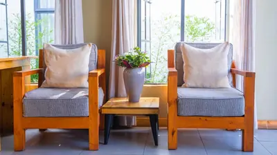 two chairs with a vase sitting on a table with a vase at Pamoja Farm Villas in Karatu