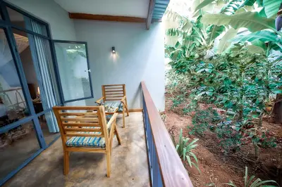 two chairs sitting on the porch of a house at Pamoja Farm Villas in Karatu