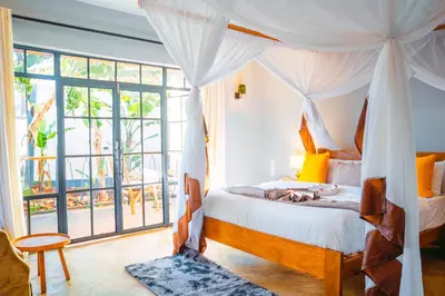 a bedroom with a bed and a large window at Pamoja Farm Villas in Karatu