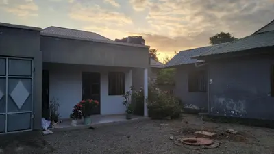 a group of houses with the sunset in the background at Milele Homestay in Boma la Ngombe