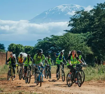 a group of people riding bikes on a dirt road at Milele Homestay in Boma la Ngombe