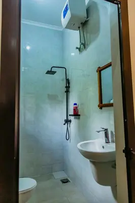 a bathroom with a sink and a toilet and a shower at Dodo homes in Uru