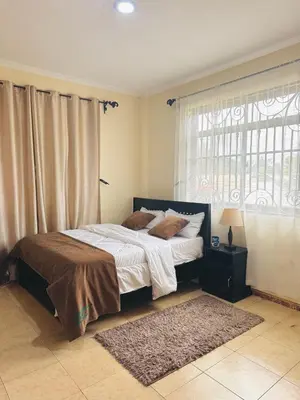 a bedroom with a bed and a window and a rug at In arusha nests in Arusha
